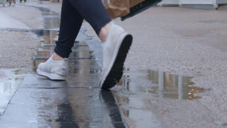 Tracking-Shot-Over-Puddle-as-Pedestrian-Walks-Past
