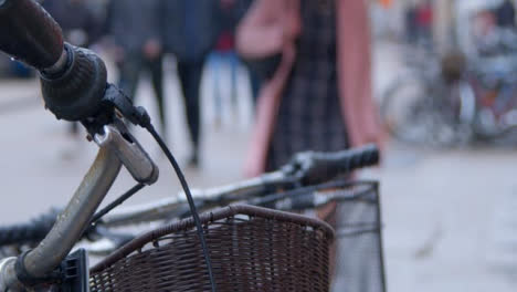 Close-Up-Shot-of-Bicycle-Handle-with-Pedestrians-In-Background