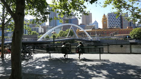 Melbourne-Australien-Fußgängerbrücke-Yarra-River-Jenseits-Von-Mädchen-Auf-Bank