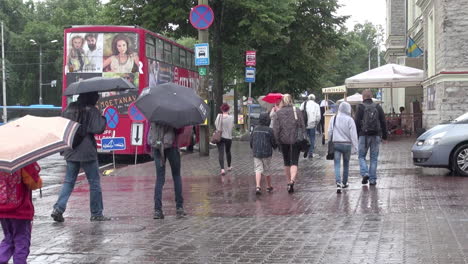Tallinn-Estonia-red-bus-and-people-walking-with-umbrellas