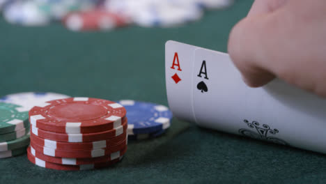 Extreme-Close-Up-Shot-of-Poker-Player-Looking-at-Pocket-Aces