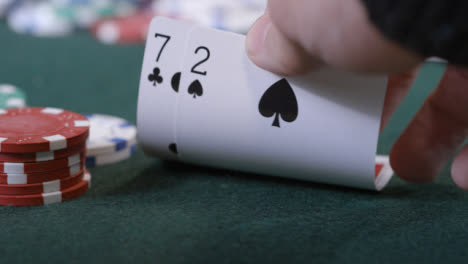 Extreme-Nahaufnahme-Eines-Pokerspielers,-Der-Vor-Dem-Falten-Auf-Sieben-Zwei-Schaut