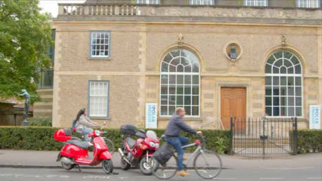 Tracking-Shot-of-Cyclists-Passing-In-Front-of-Scott-Polar-Research-Institute-Museum