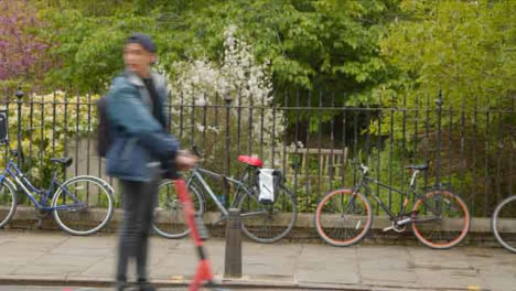Wide-Shot-of-Person-On-Electric-Scooter-Passing-In-Front-of-Bicycles