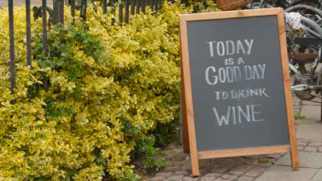Tracking-Shot-Orbiting-Blackboard-Sign-Reading-Today-Is-a-Good-Day-to-Drink-Wine