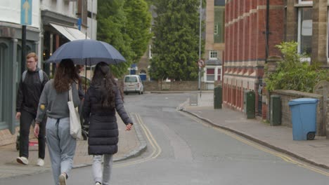 Wide-Shot-of-Pedestrians-Walking-In-Rain