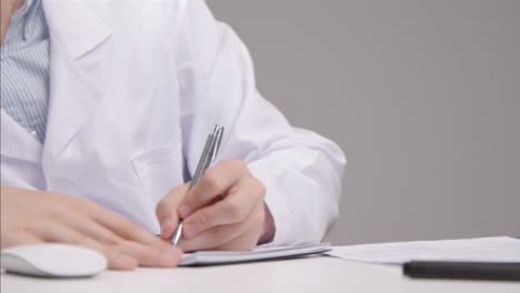 Panning-Shot-Revealing-Medical-Professional-Going-Through-Documents-at-His-Desk