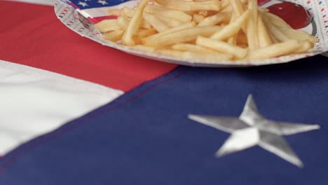 Extreme-Close-Up-Shot-of-Rotating-United-States-Flag-with-Bowl-of-Fries-and-Cup