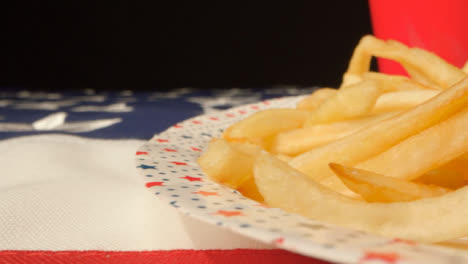 Schiebeschuss-Entlang-Der-Flagge-Der-Vereinigten-Staaten-Von-Amerika-Vorbei-An-Einem-Teller-Mit-Pommes