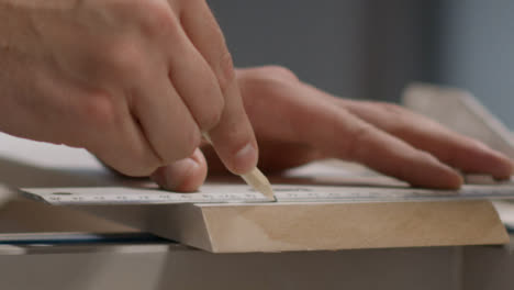 Nahaufnahme-Der-Hand-Mit-Bleistift,-Um-Schnittlinien-Auf-Der-Sockelleiste-Zu-Markieren