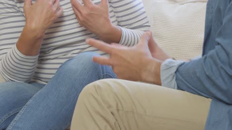 Sliding-Shot-of-Middle-Aged-Couples-Hand-Gestures-as-They-Argue