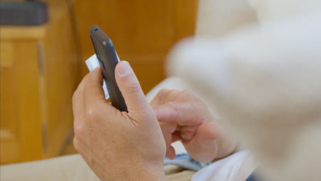 Pull-Focus-Shot-of-Middle-Aged-Man-Scrolling-On-His-Smartphone