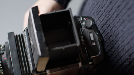 High-Angle-Shot-of-a-Persons-Hands-Holding-Mamiya-RB67-and-Taking-Photo
