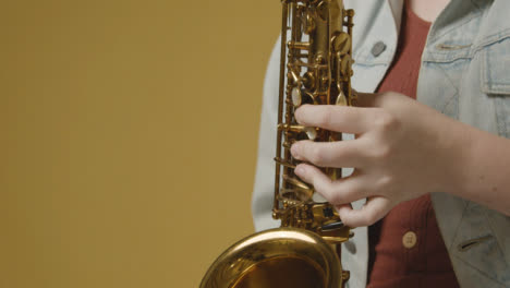Close-Up-Shot-of-Model's-Hands-Playing-a-Saxophone