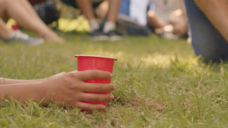 Close-Up-Shot-of-Festival-Goer's-Hand-Holding-Plastic-Beer-Cup