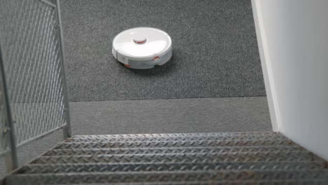 High-Angle-Shot-Down-Stairs-of-Robotic-Vacuum-Cleaner-Cleaning-Carpet