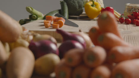 Pull-Focus-Shot-of-Pile-of-Vegetables-On-Rustic-Wooden-Table