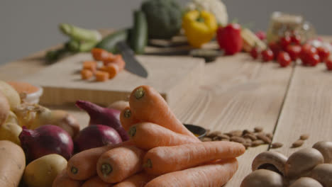 Ziehen-Sie-Den-Fokusschuss-Von-Einem-Haufen-Gemüse-Auf-Einem-Rustikalen-Holztisch