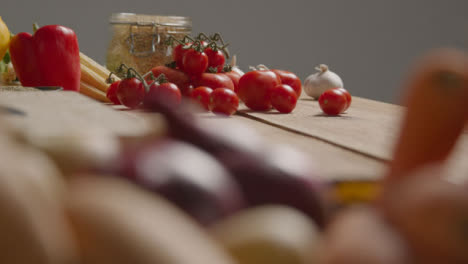 Pull-Focus-Shot-of-a-Pile-of-Vegetables-On-a-Rustic-Wood-Table
