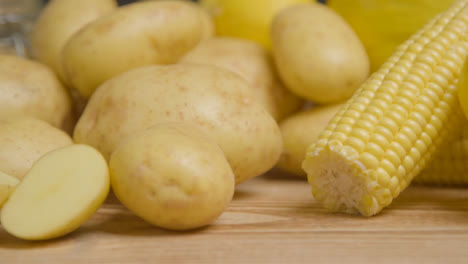 Close-Up-Shot-of-Sweetcorn-and-Potatoes-On-a-Rustic-Wooden-Table