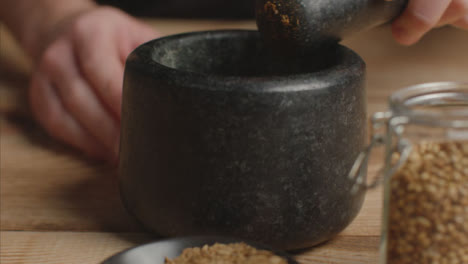 Close-Up-Hand-Using-Mortar-and-Pestle-to-Grind-Cumin-Spice