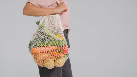 Tracking-Shot-of-Young-Adult-Woman-Holding-Bag-of-Vegetables-01