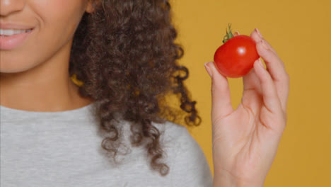 Close-Up-Shot-of-Young-Adult-Woman-Holding-Tomato