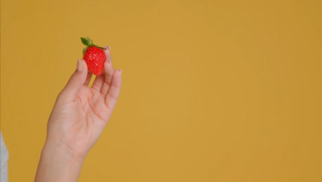 Close-Up-Shot-of-Young-Adult-Woman-Holding-Strawberry