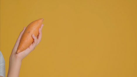 Close-Up-Shot-of-Young-Adult-Woman-Holding-Sweet-Potato