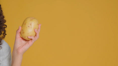 Close-Up-Shot-of-Young-Adult-Woman-Holding-Potato
