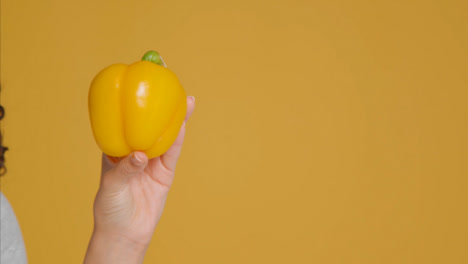 Close-Up-Shot-of-Young-Adult-Woman-Holding-Pepper