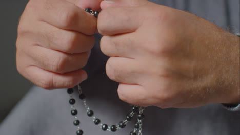 Close-Up-Shot-of-Senior-Mans-Hands-Holding-Rosary-Beads