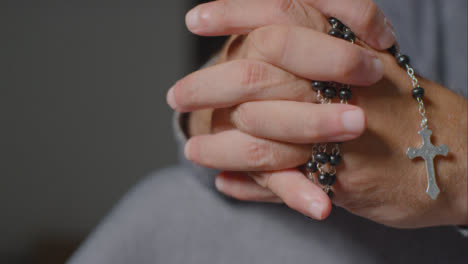 Sliding-Shot-of-Senior-Mans-Hands-Holding-Rosary-Beads