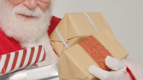 Close-Up-Shot-of-Santa-Holding-Some-Gifts-and-Presents