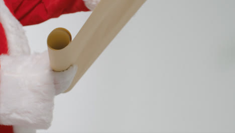 Close-Up-Shot-of-Santas-Hands-Holding-Paper-Scroll