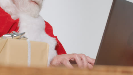 Low-Angle-Shot-of-Santa-Typing-On-a-Laptop