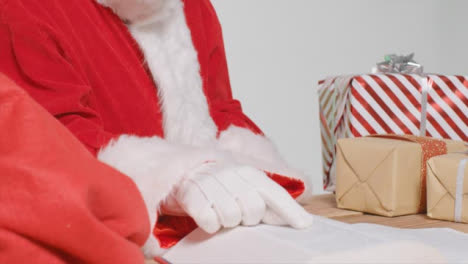Close-Up-Shot-of-Santa-Placing-Gifts-In-Big-Red-Sack