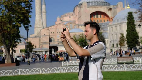 Medium-Shot-of-Young-Man-Taking-Photos-In-Front-of-Hagia-Sophia