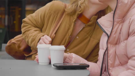 Mid-Section-of-Woman-Joining-Friend-for-Coffee