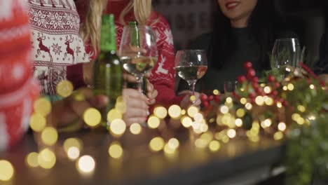 Tracking-Shot-of-Friends-Sitting-at-a-Bar-with-Drinks-During-Christmas-Celebrations
