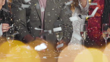 Close-Up-of-Confetti-Falling-on-Friends-Celebrating-New-Years-Eve