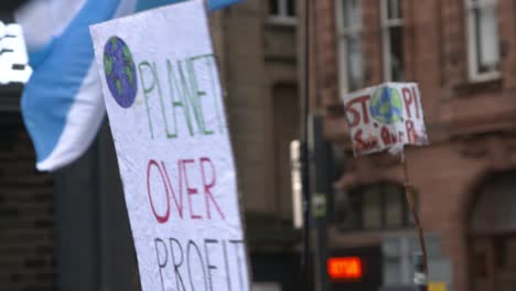 Handheld-Shot-of-'Planet-Over-Profit'-Sign-During-Climate-Change-Protests-In-Glasgow