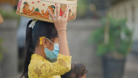 Tracking-Shot-of-Young-Girl-Carrying-Things-Through-Bali