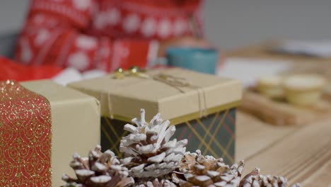 Nahaufnahme-Von-Geschenken-Und-Tannenzapfen-Auf-Dem-Tisch-Während-Der-Weihnachtszeit