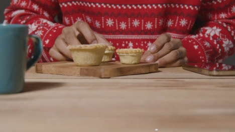 Close-Up-Shot-of-Young-Mans-Hands-Texting-and-Eating-Mince-Pie