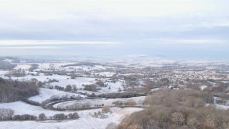 Drone-Shot-Flying-Over-Snowy-Fields-and-Trees-Toward-Cotswold-Village-Part-4-of-4