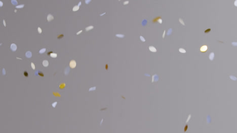 Stationary-Shot-of-White-Blue-and-Gold-Confetti-Falling-Against-Grey-Background