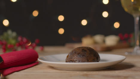 Sliding-Shot-of-Christmas-Pudding-On-a-Table