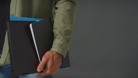Close-Up-Shot-of-Mans-Hand-Holding-Folder-and-Book