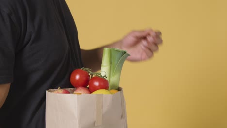 Close-Up-Side-Shot-of-Man-Putting-Tomatoes-Into-Bag-